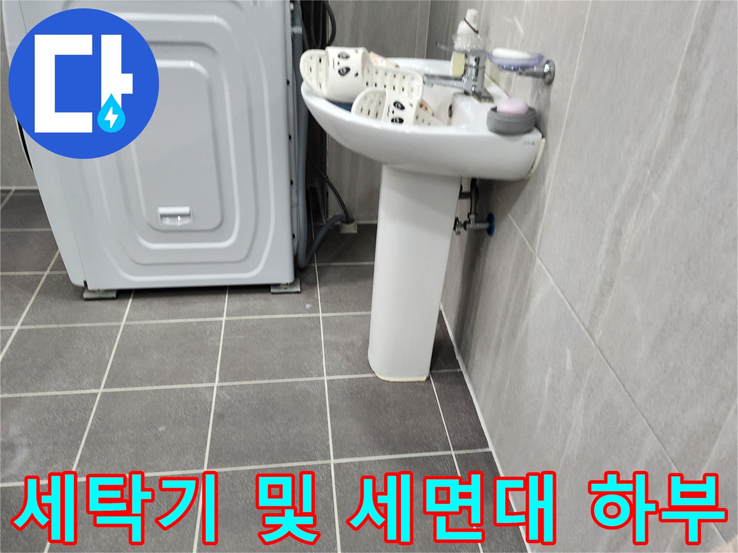 현장의 세면대 아래 배수 공간과 타일 바닥을 촬영한 사진입니다.