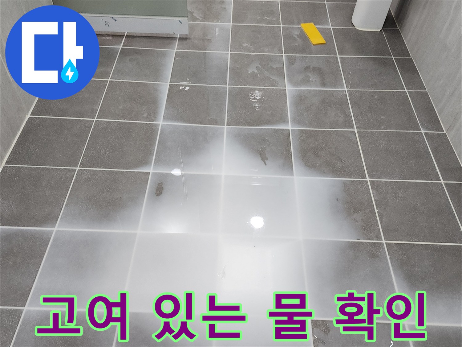 회색 욕실 타일 위로 물이 고여있는 현장 사진