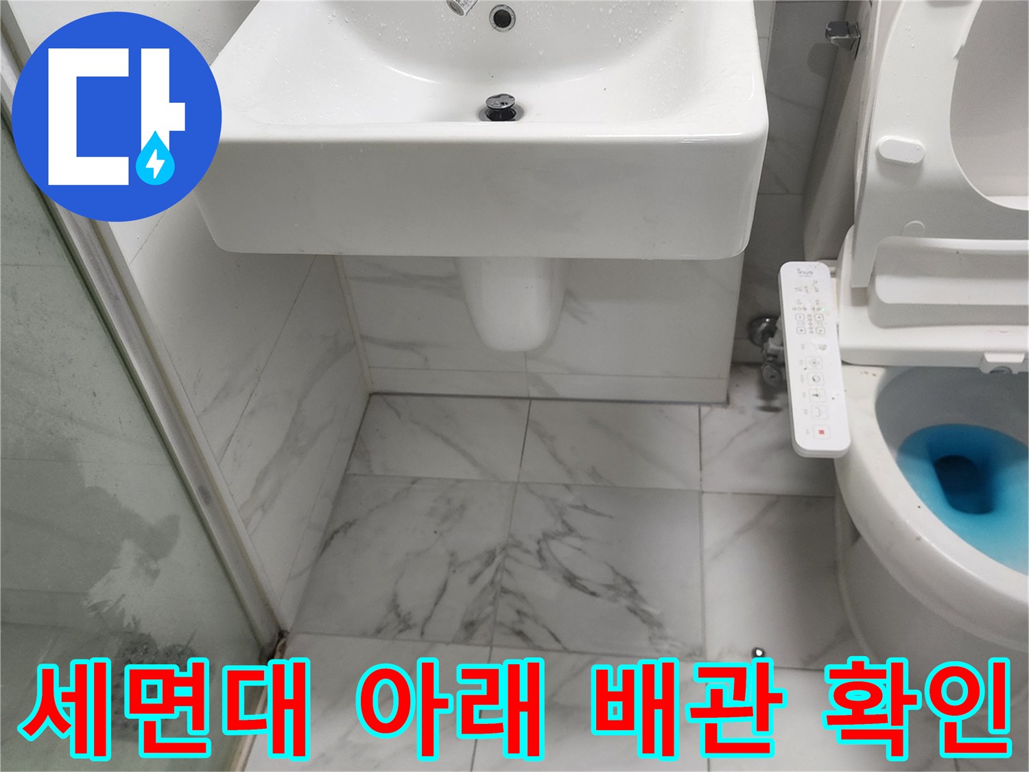 흰색 세면대 하부와 변기 옆쪽 타일 벽면 상세 사진