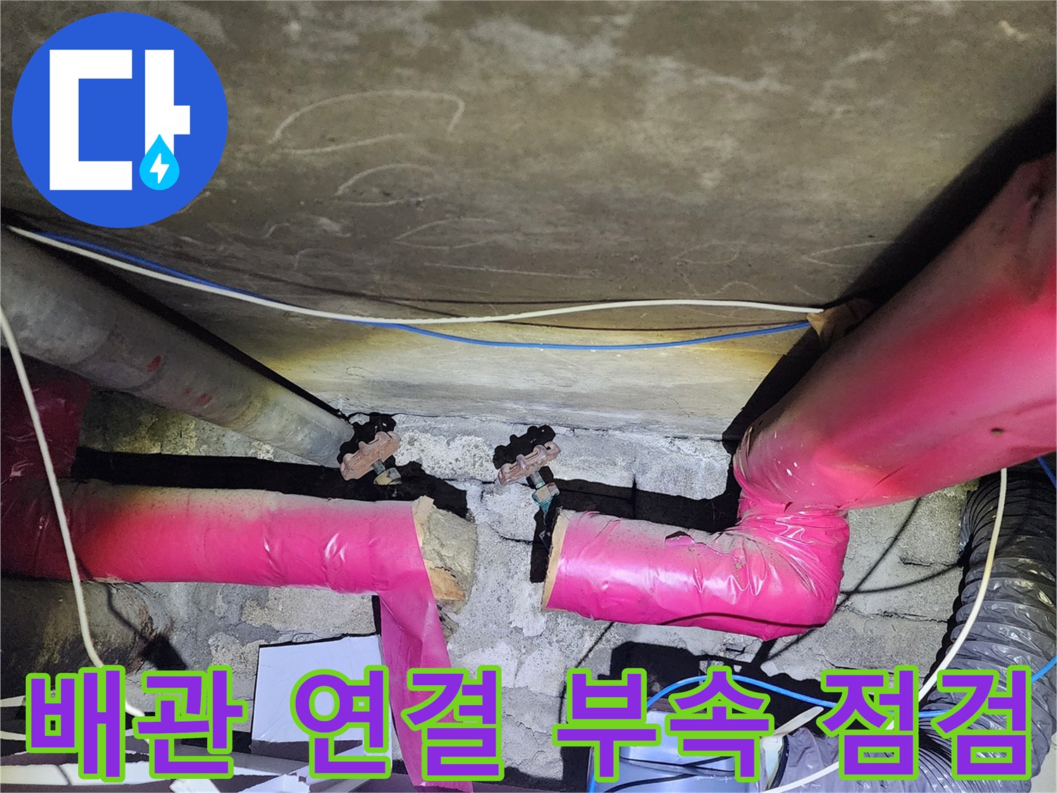 분홍색 보온재로 덮인 배관의 금속 연결 부위 상세 사진입니다.