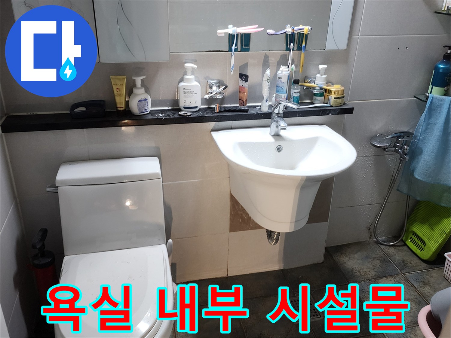 세면대와 변기가 있는 화장실의 전체적인 모습입니다.