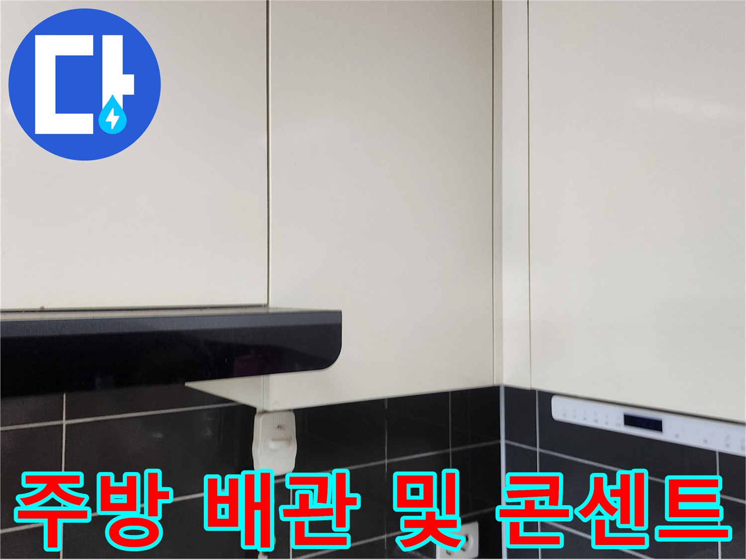 싱크대 하단 타일 벽면에 설치된 배관과 전기 시설물