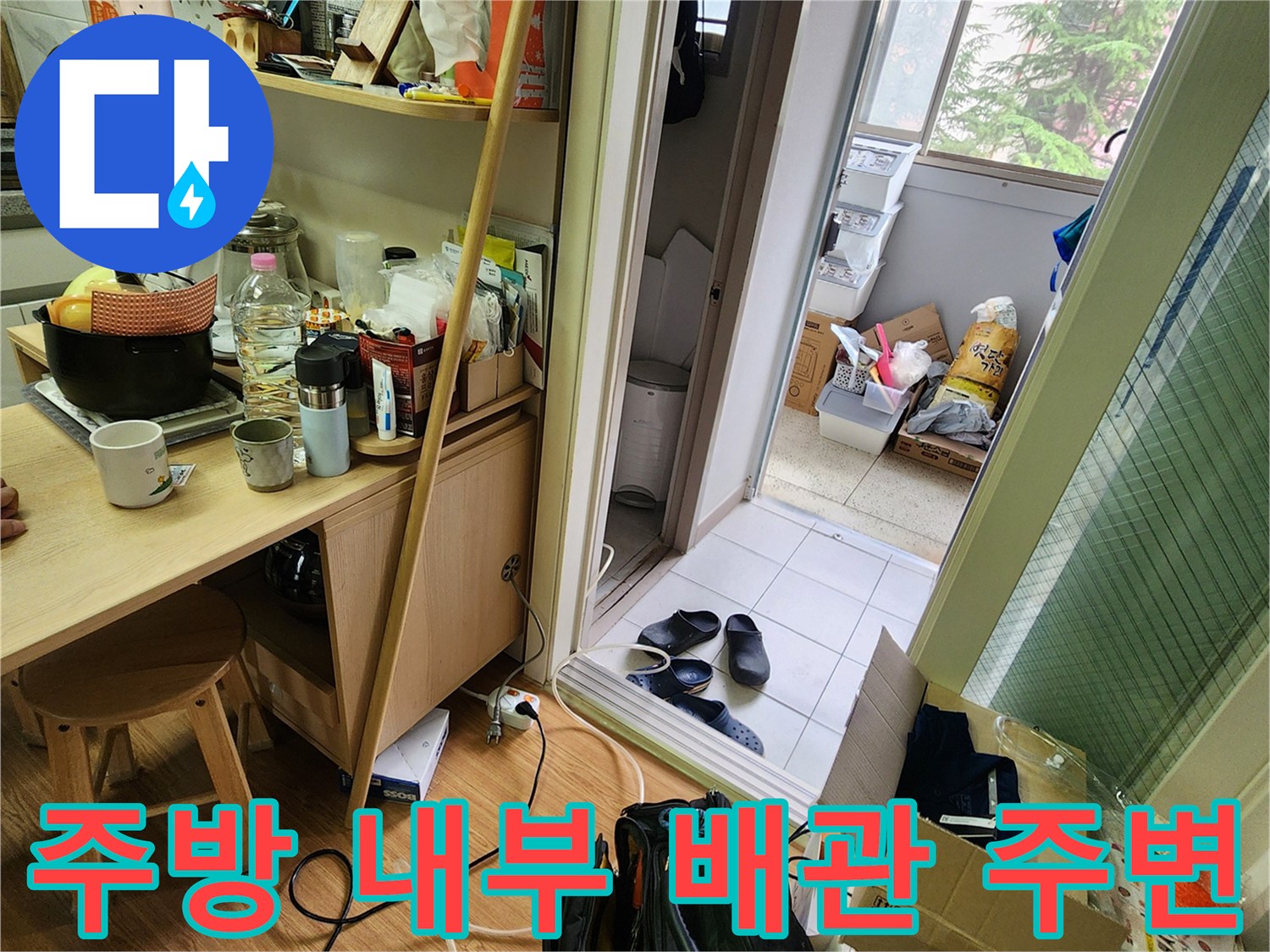 싱크대 하부장 선반과 바닥에 놓인 장비 및 생활 용품들