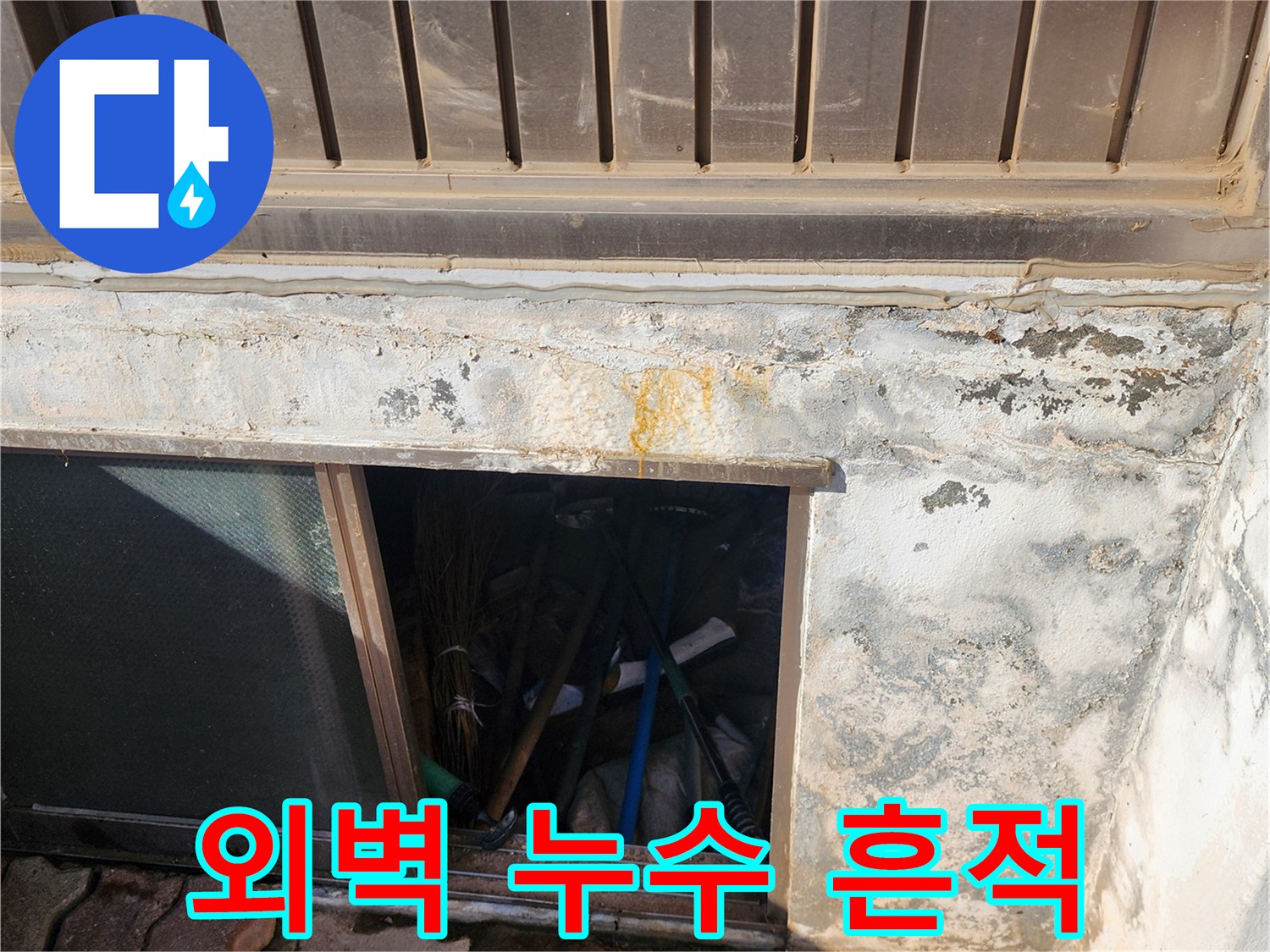 건물 아래쪽 벽면의 황색 변색과 습기 발생 부위
