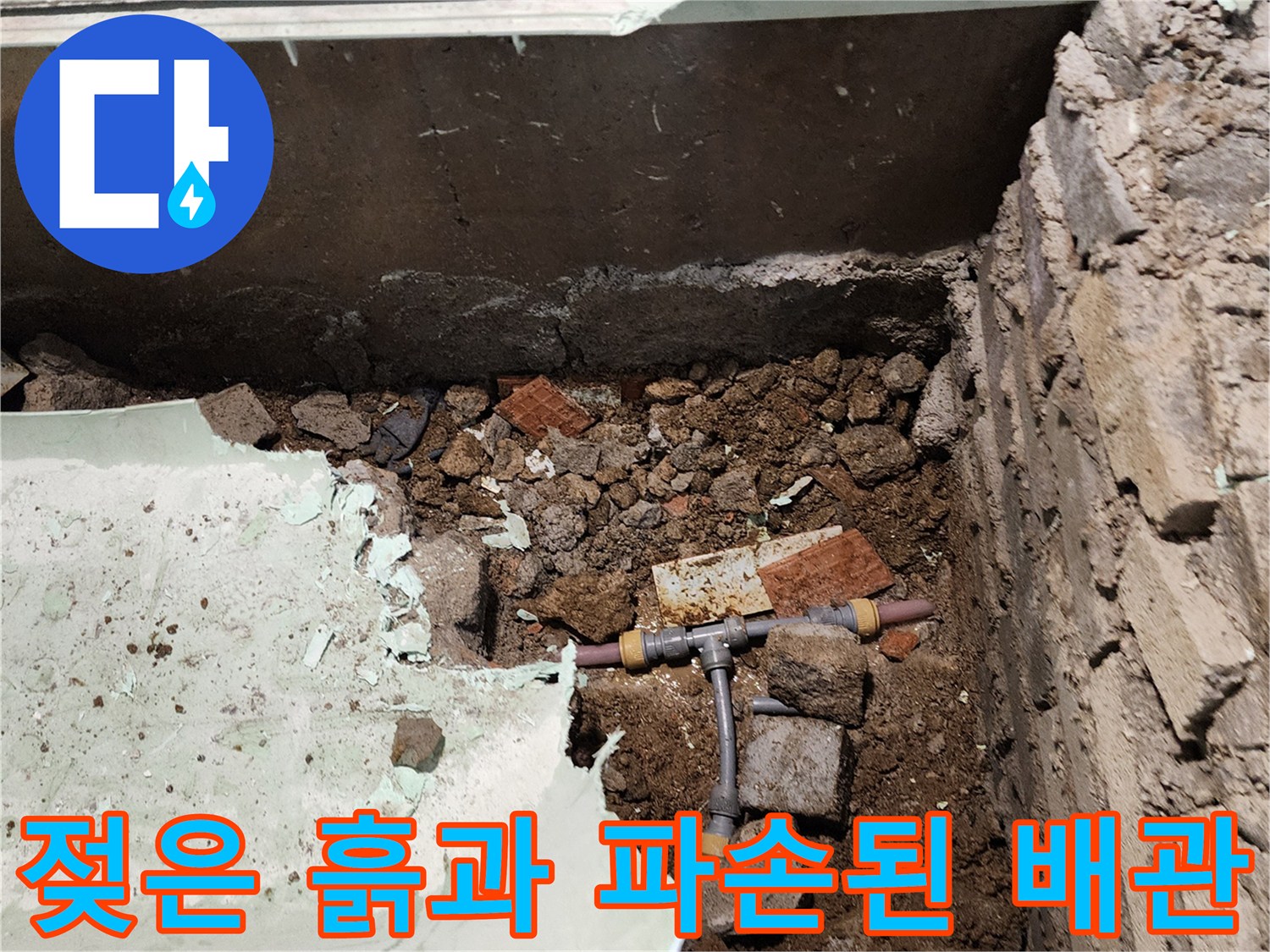 물에 젖은 흙 사이로 보이는 손상된 배관 연결 부위