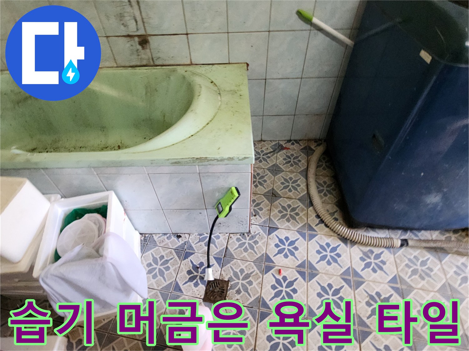 푸른색 문양의 욕실 바닥 타일과 세탁기 배관 연결부