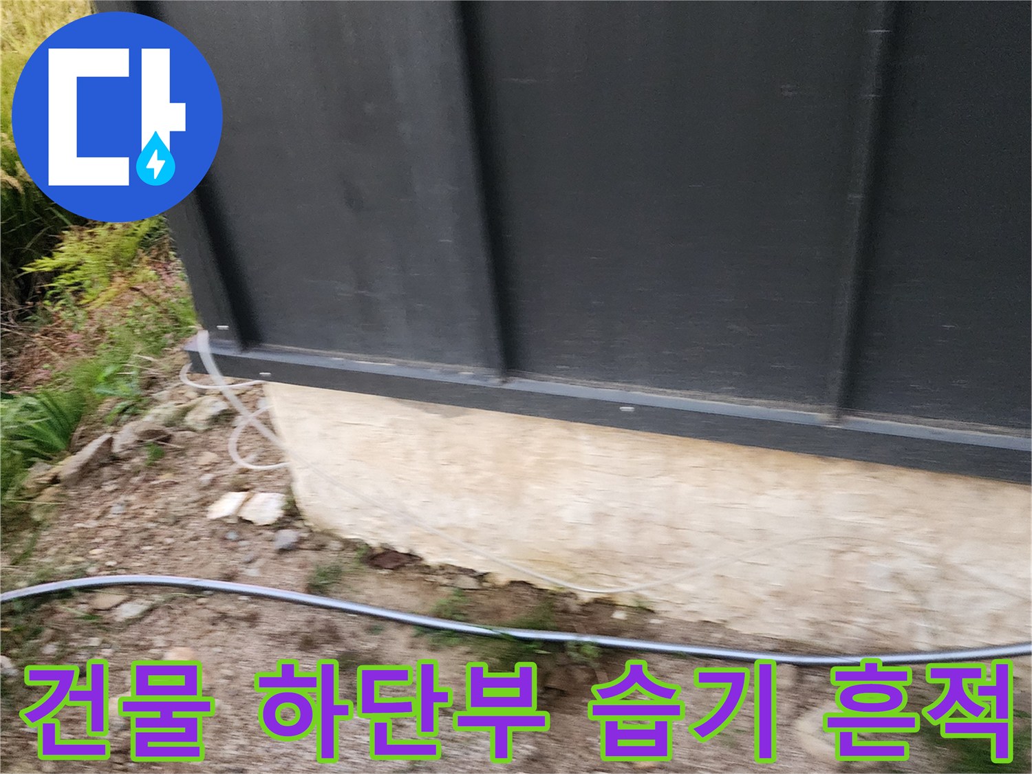 검은색 외벽 패널 아래 콘크리트 마감 부위의 수분 침투 상태