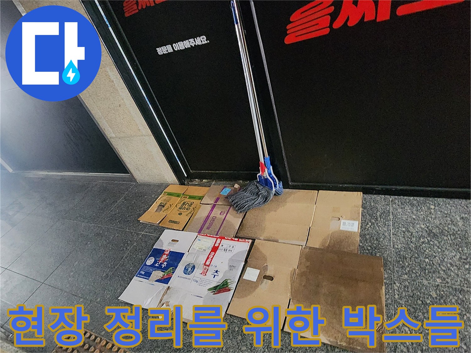 상가 입구 바닥에 쌓인-종이 상자들
