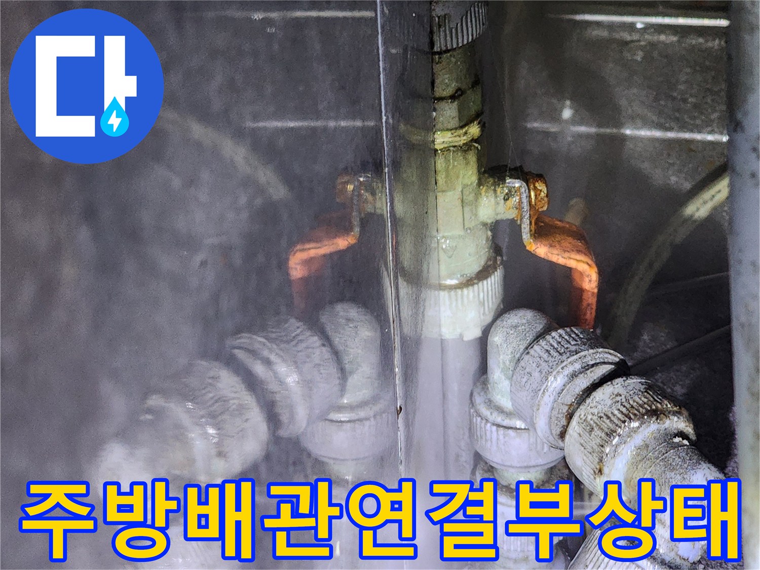 식당 주방 하부의 복잡한 배관 연결 부위와 밸브 상태를 보여주는 사진