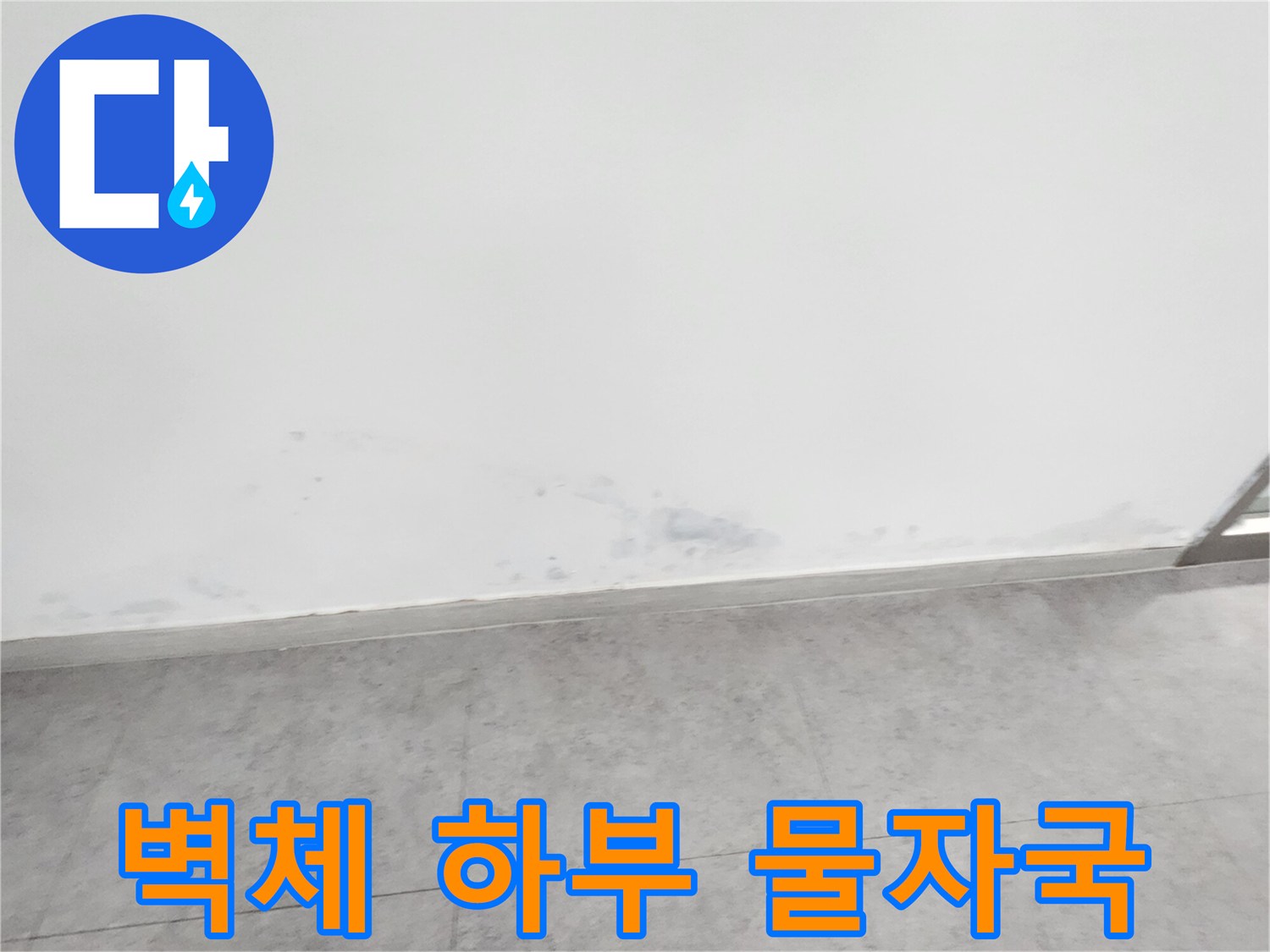 깨끗한 흰색 벽면 아래에 나타난 불규칙한 어두운 얼룩