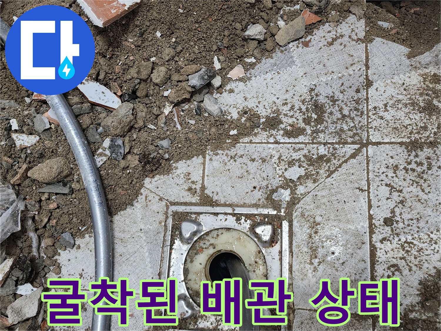타일 제거 후 드러난 하수구 배관 및 주변 흙과 잔해물