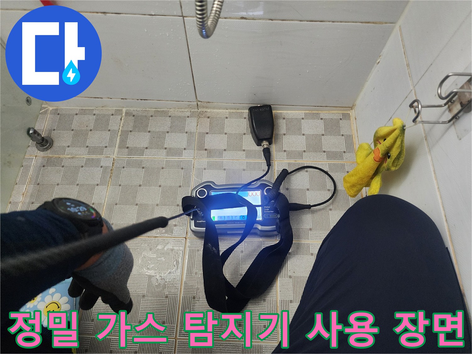 바닥 타일 위에서 작동 중인 배관 누수용 가스 탐지 장비입니다.