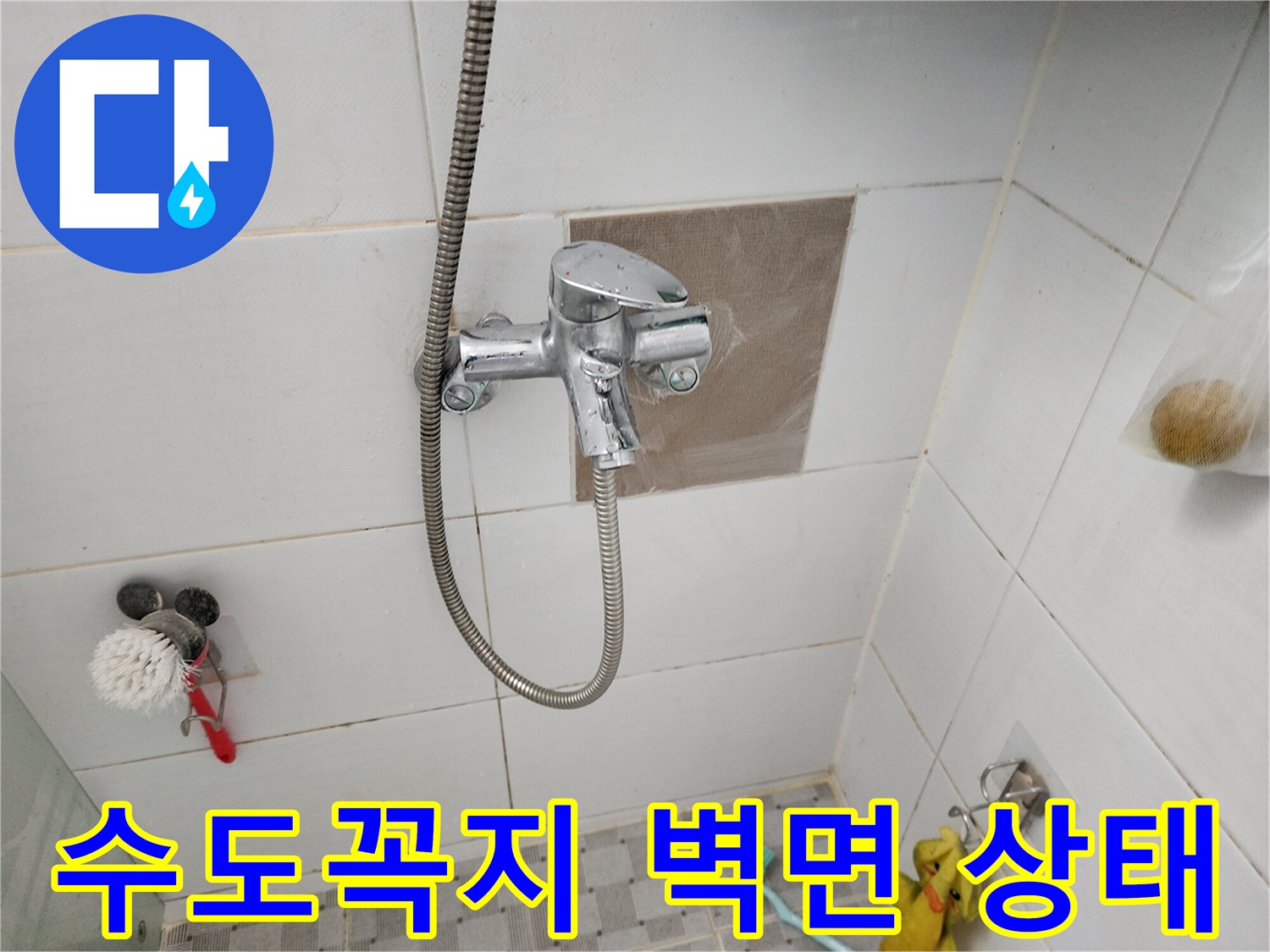벽면에 설치된 샤워 수전과 주변 타일 모습