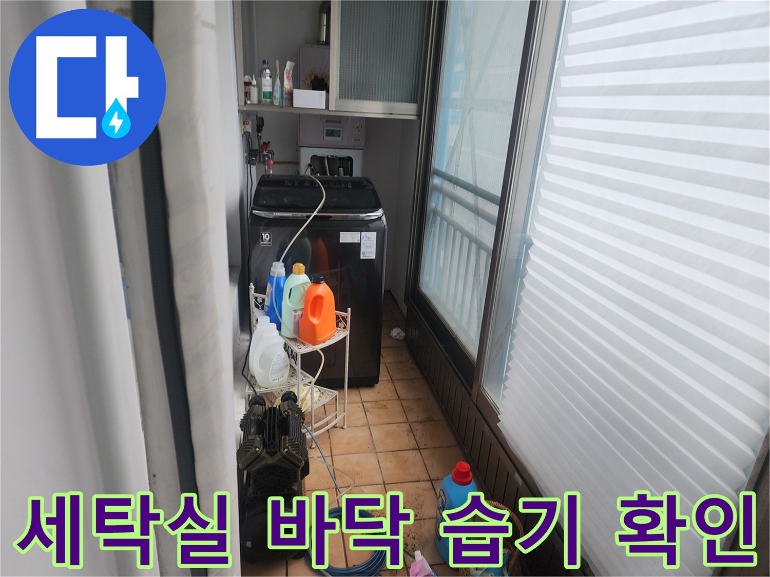 세탁기 주변의 젖은 타일과 배관 연결 부위 근접 촬영