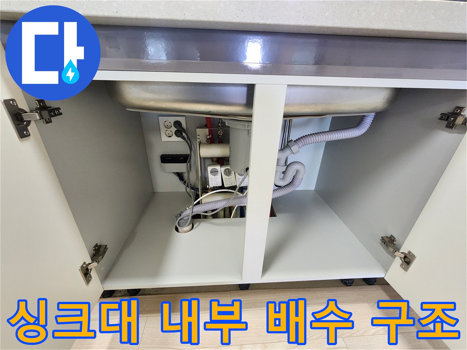 싱크대 아래쪽의 굴곡진 배수 호스와 주변 설비