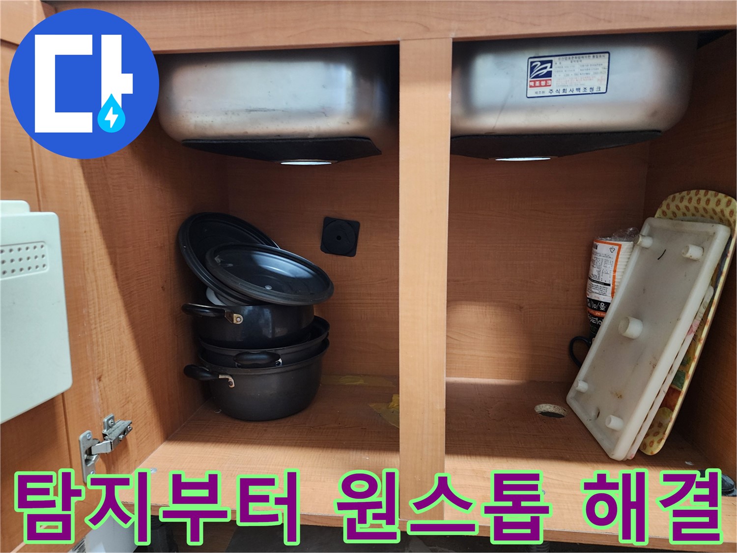 싱크대 하부장 내부 - 누수 지점을 찾기 위해 집중하고 있습니다.