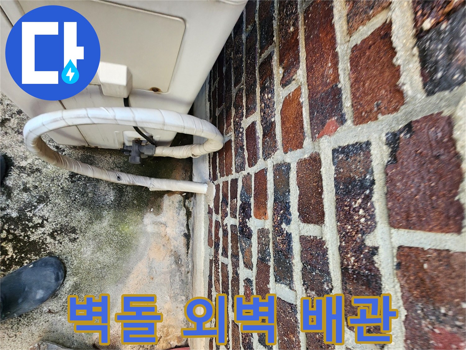 벽돌 구조물과 흰색 배관이 맞닿은 지점의 근접 촬영
