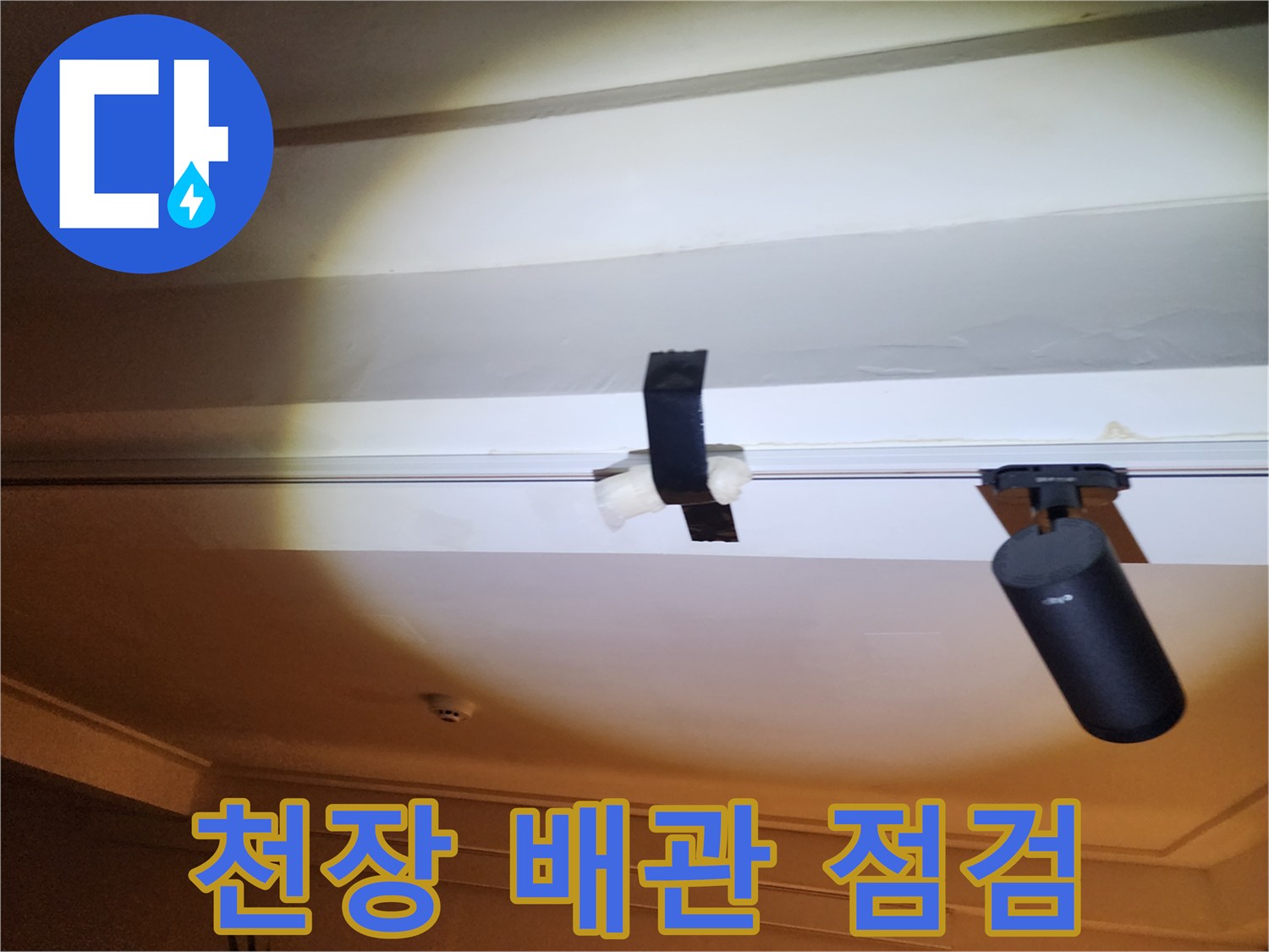 천장 내부의 배관과 연결 부위를 점검하는 모습입니다.