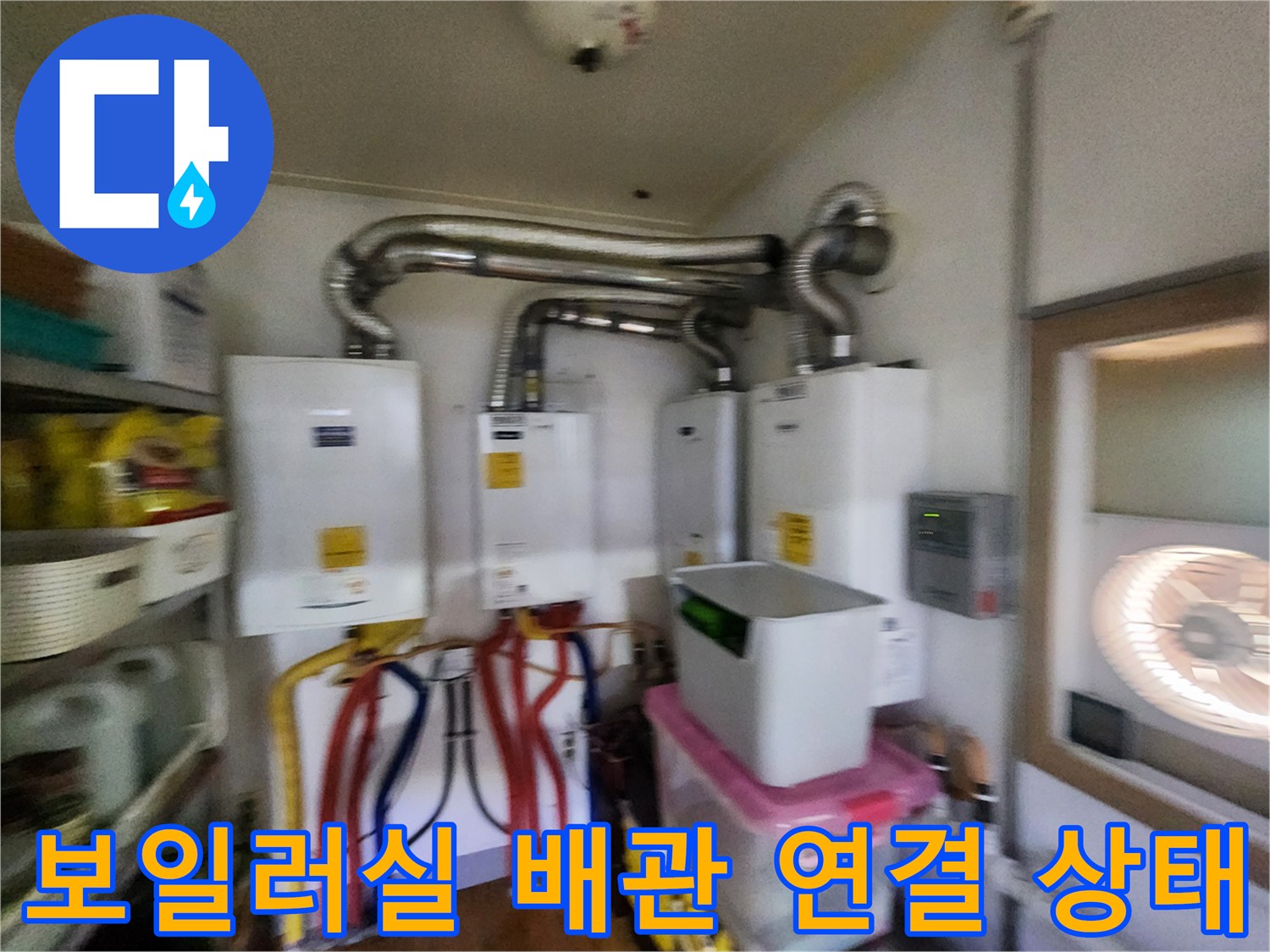 보일러실의 은색 연통과 아래쪽으로 연결된 다채로운 배관들