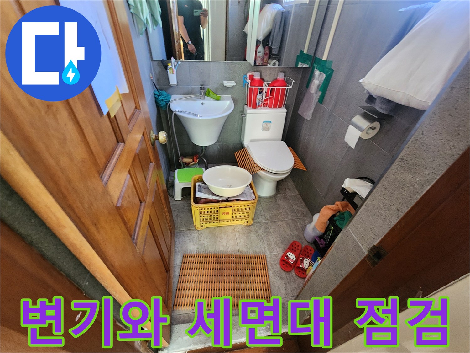 점검 중인 화장실의 세면대와 양변기 배치 상태입니다.