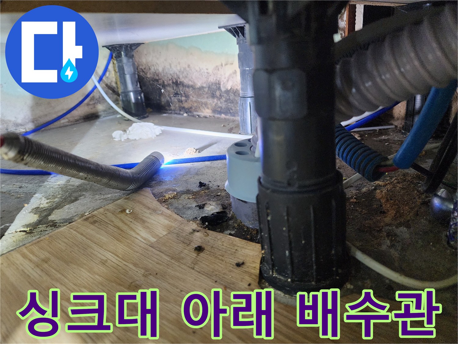 주방 싱크대 하부의 복잡한 배수관과 물샘 흔적