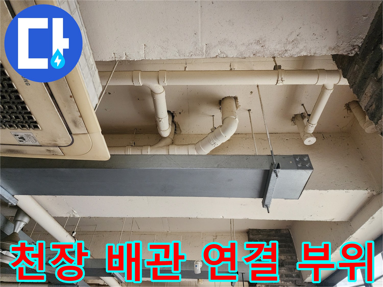 상가 천장의 노출된 흰색 PVC 배관과 고정 장치