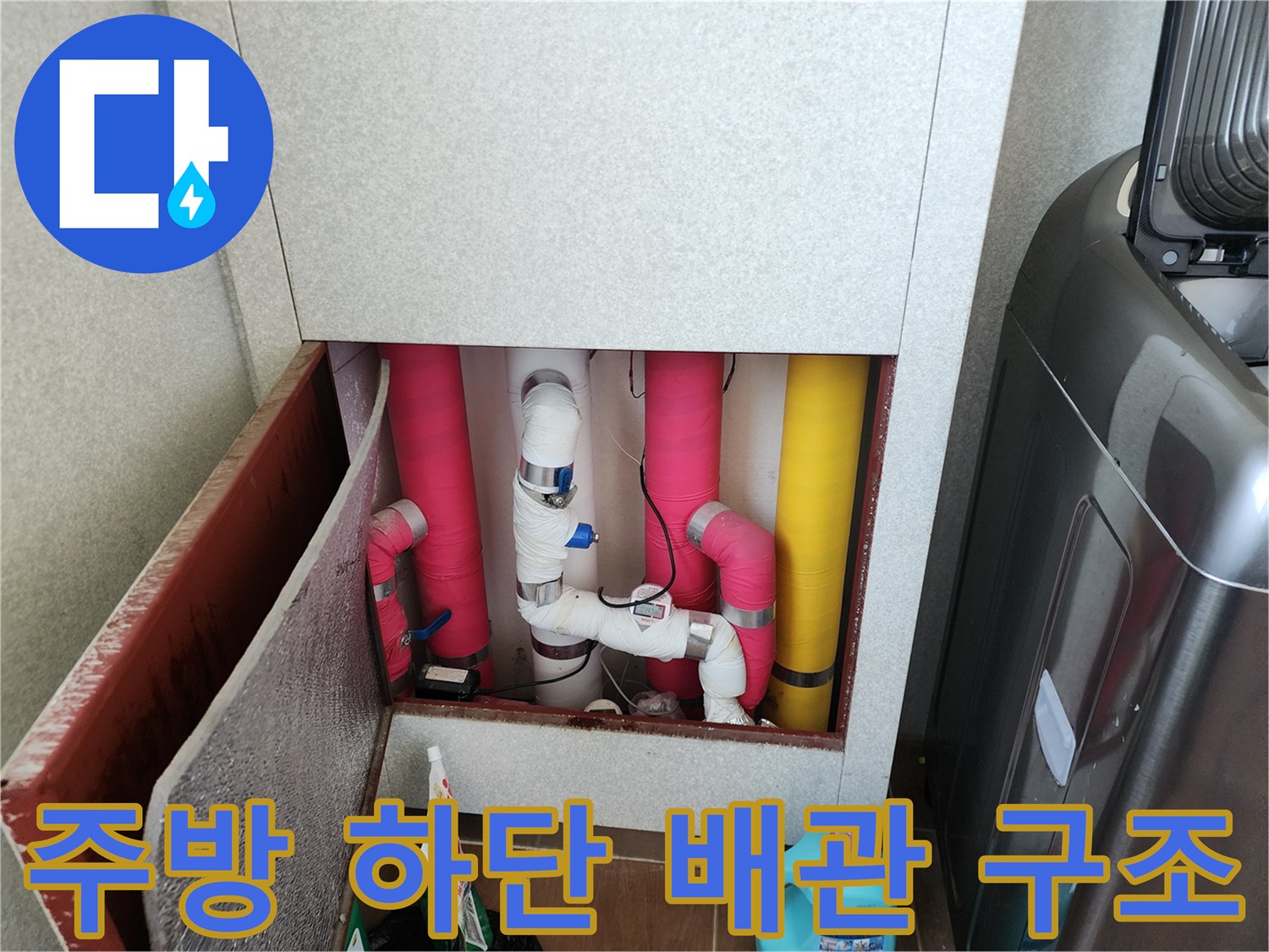 싱크대 밑에 설치된 다양한 색상의 보온 배관들