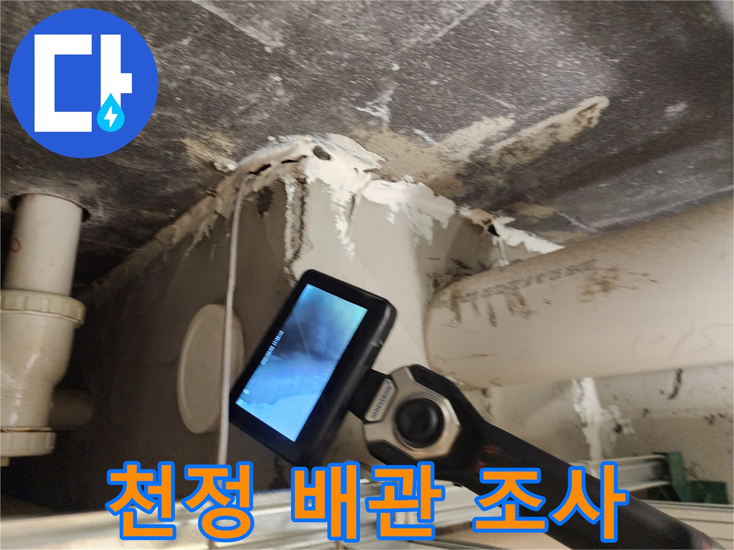 점검구 내부의 젖은 배관과 내시경 장비