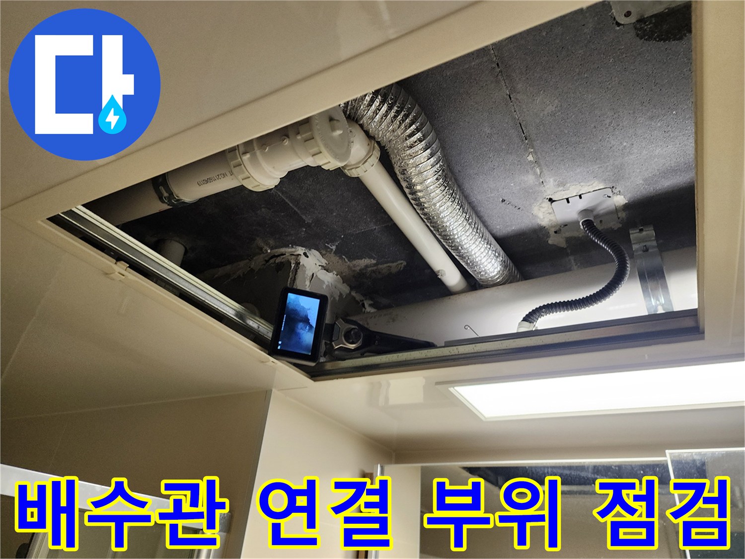 점검구 안쪽의 하얀 배관과 검은색 전선 및 자바라 호스 노출 상태