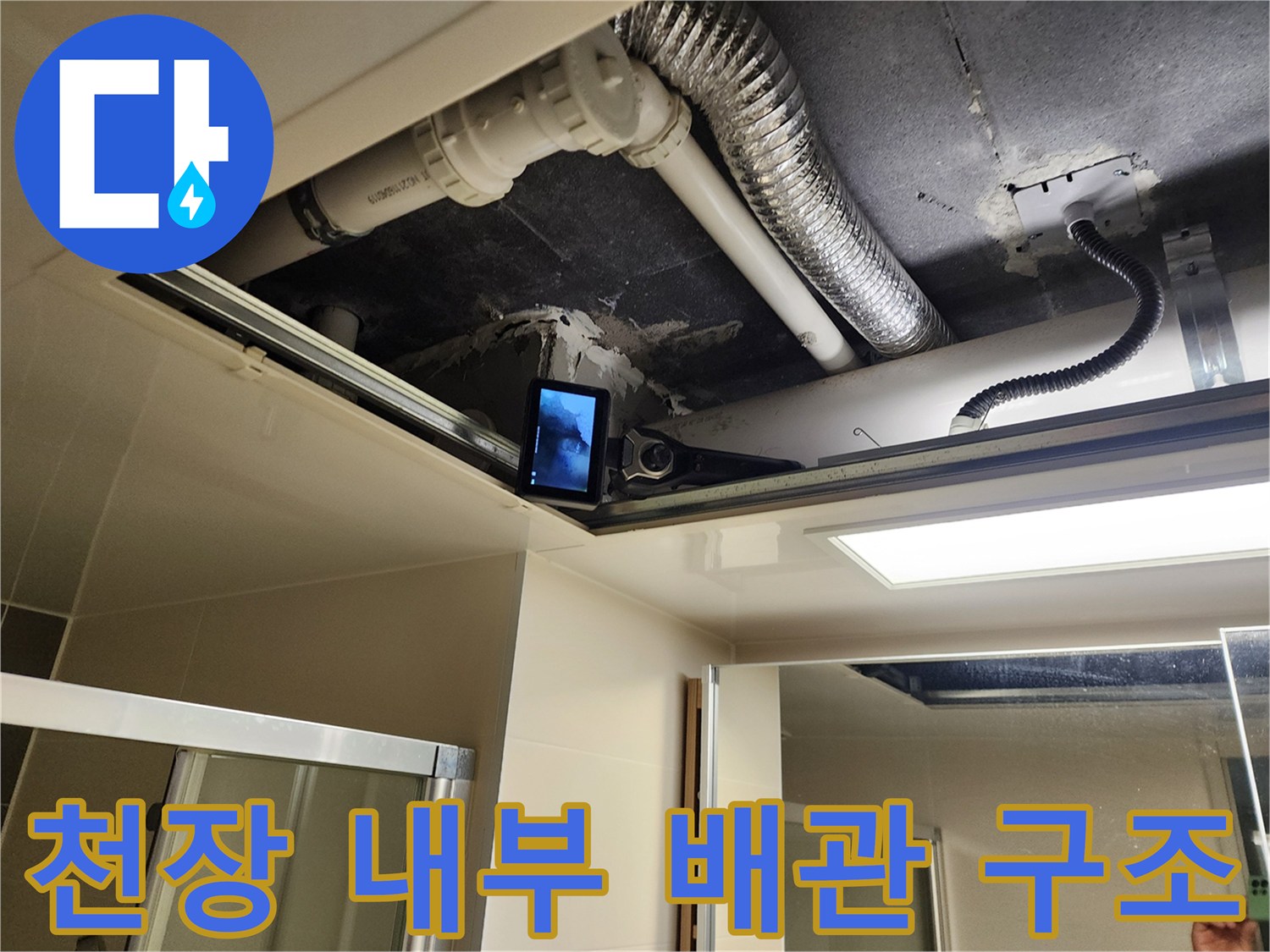 천장 점검구로 보이는 하얀색 배관과 은색 자재
