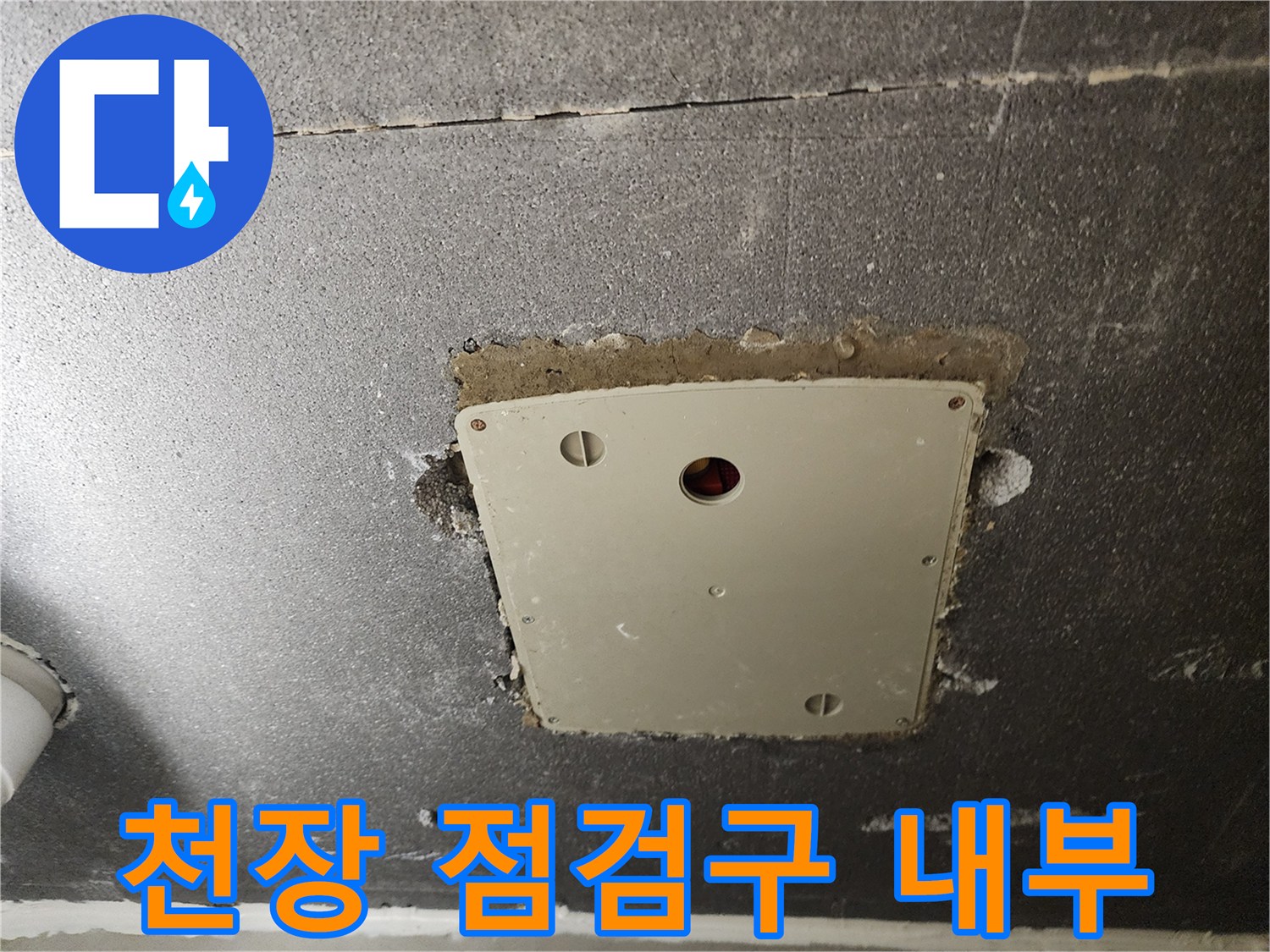 천장 타공 부위에 노출된 배관 점검용 플라스틱 판