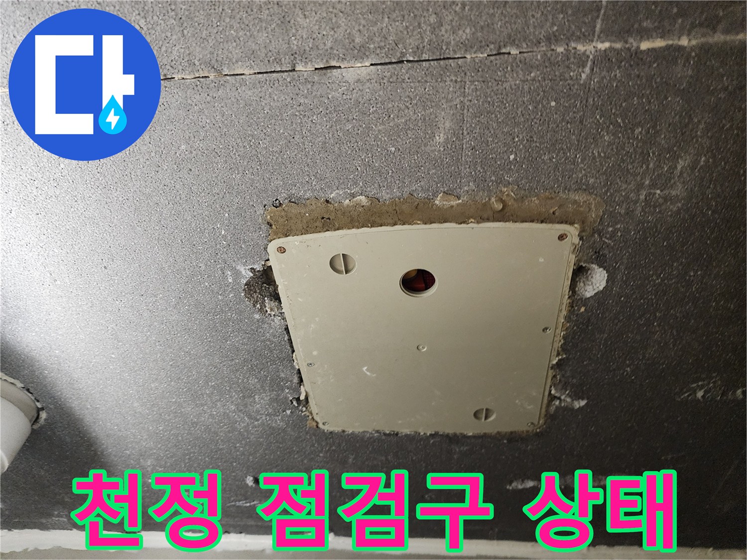 천정 내부의 배관과 전기 설비가 노출된 점검구 모습입니다.