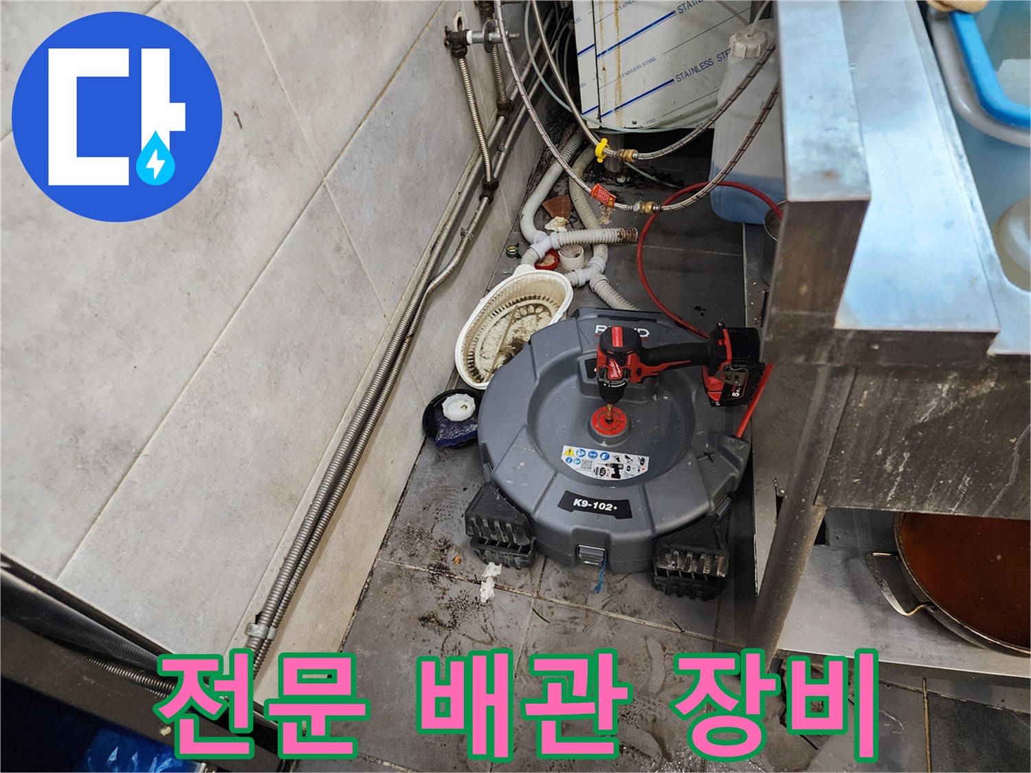 막힌 하수구를 뚫기 위해 세팅된 전동 스프링 기계