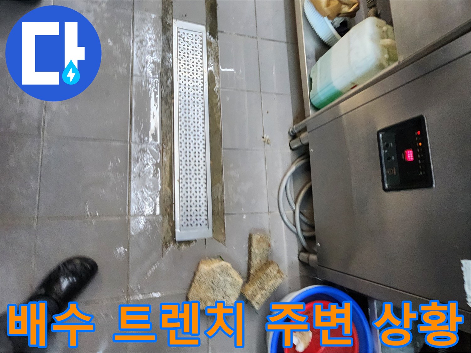 물기가 흥건한 주방 바닥과 금속 배수 덮개