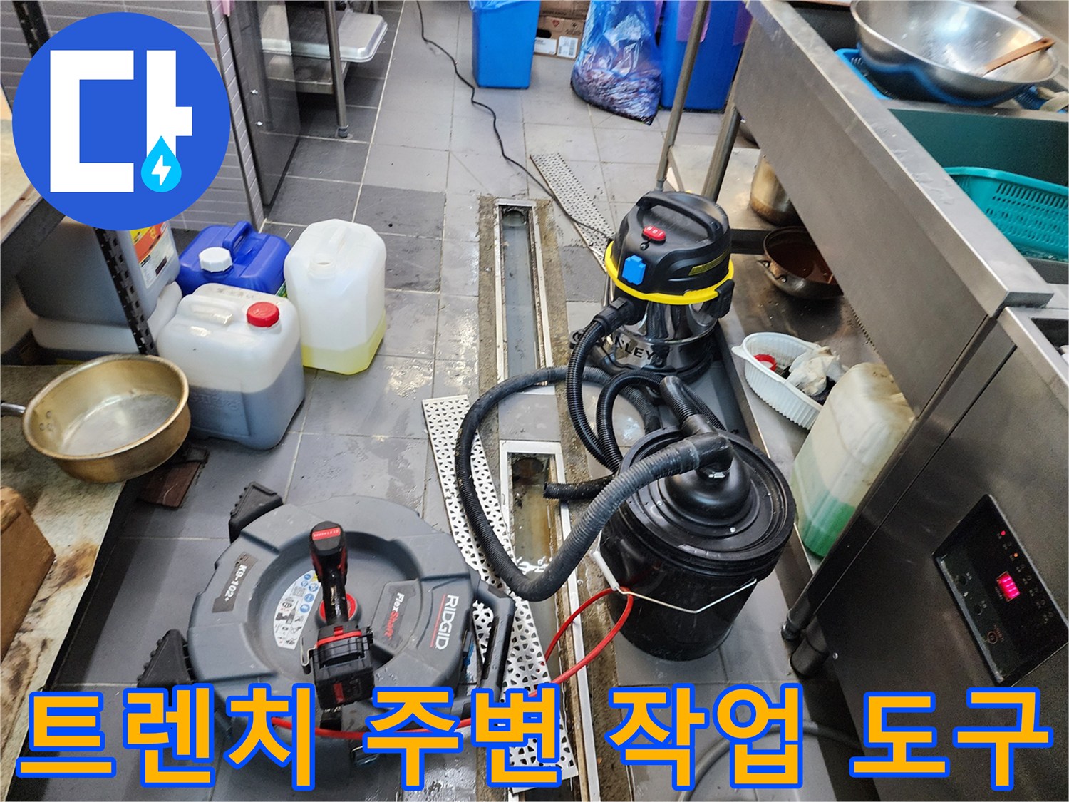 배수 트렌치 옆에 놓인 전동 스프링 장비와 배관 흡입기 세트