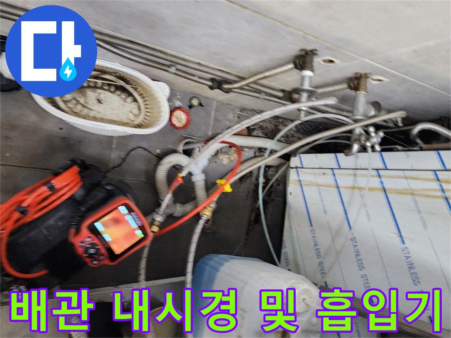 주방 바닥 작업 현장-배관 점검용 장비와 청소 도구 배치