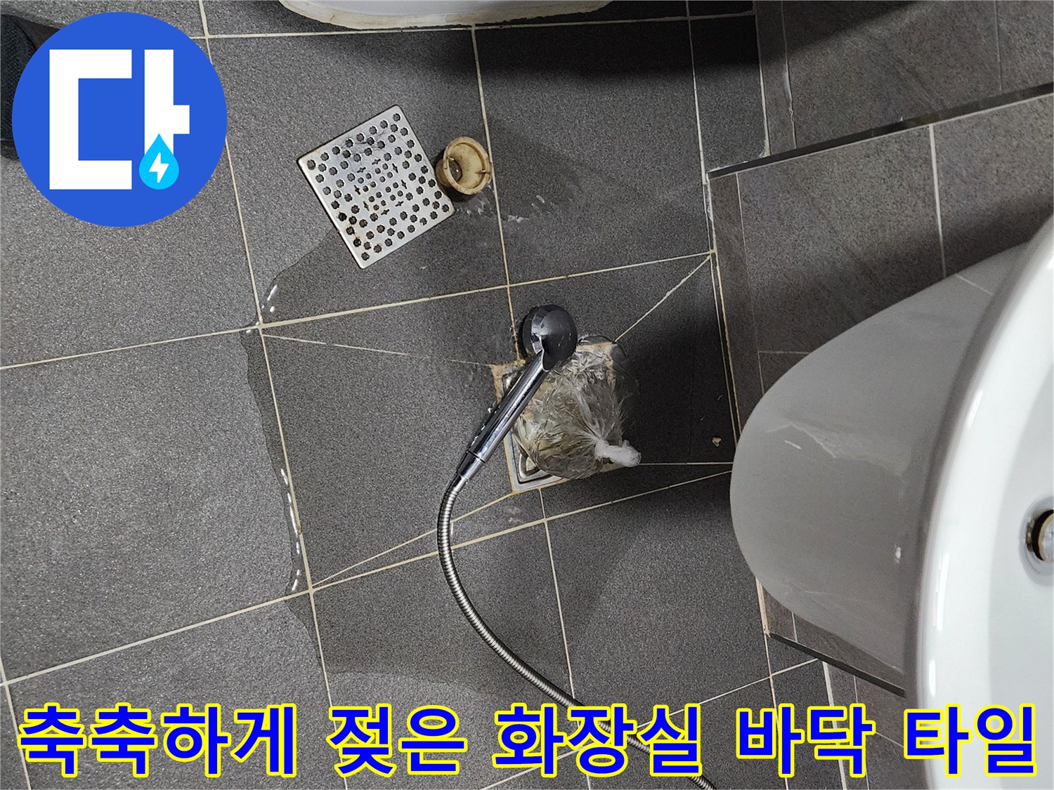 화장실 배수구 주변 타일이 물기에 젖어 있는 현장 사진