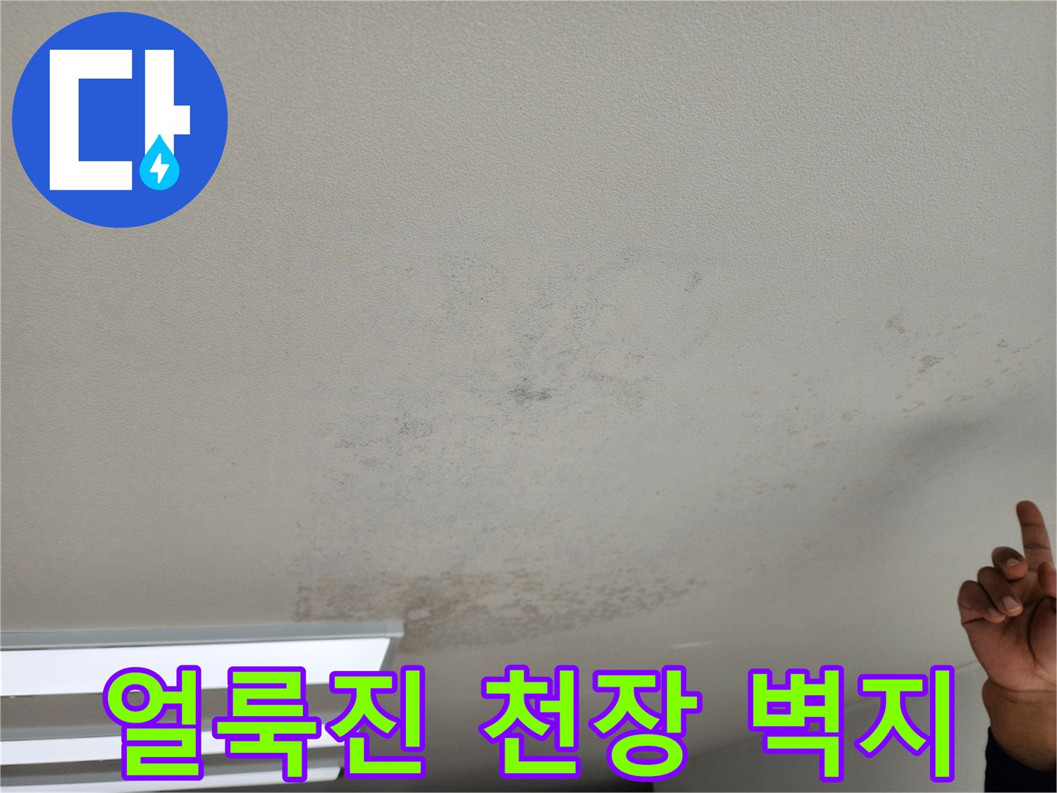 누수로 인해 어둡게 변색된 천장의 넓은 얼룩 부위