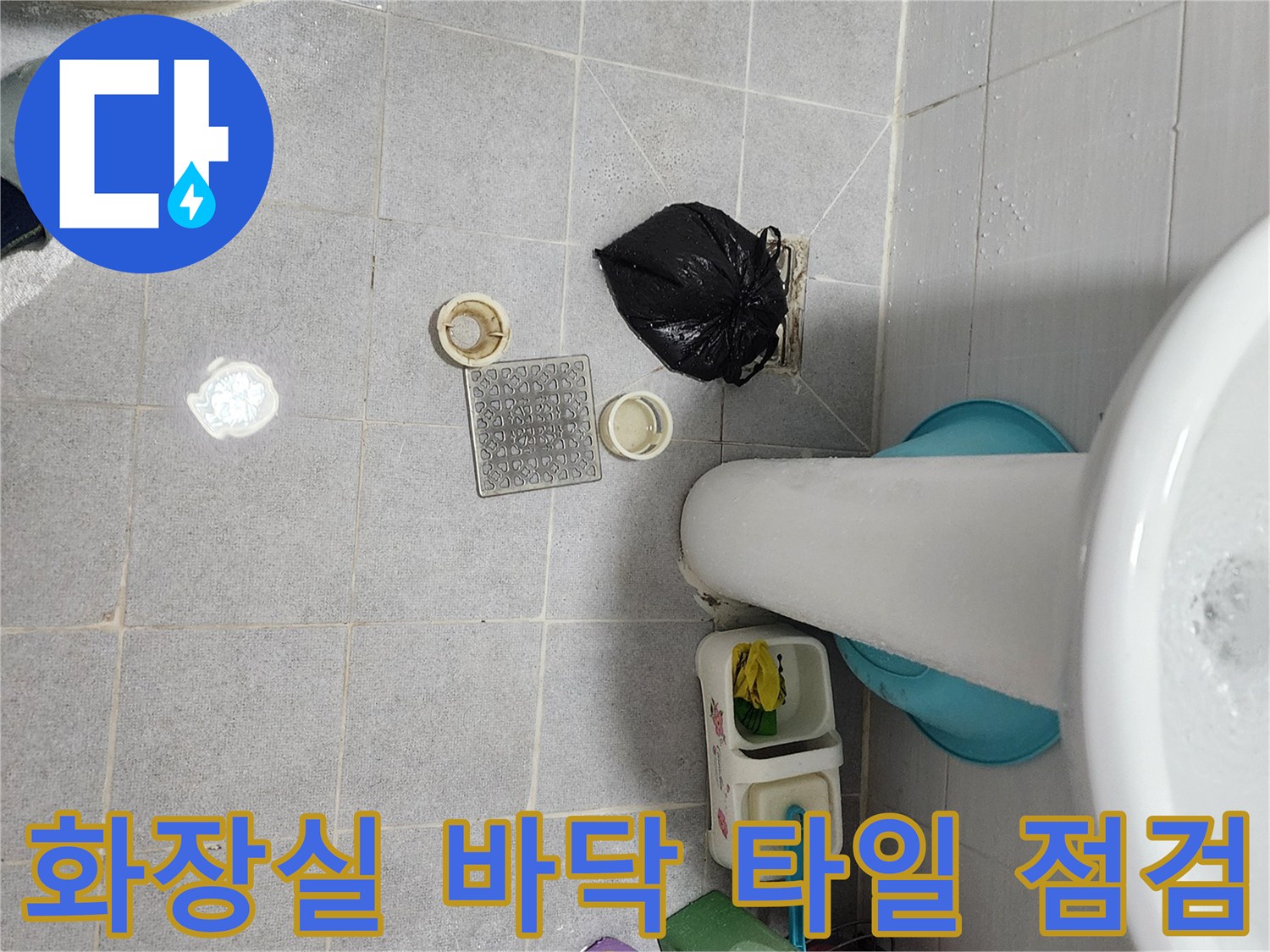 세면대 밑 화장실 바닥의 배수구 부속과 타일 상태를 촬영한 사진