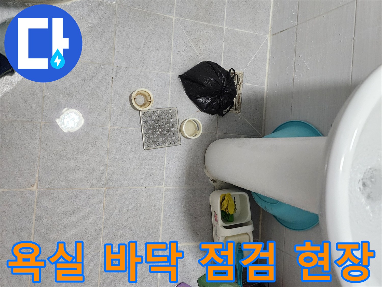 세면대 아래 욕실 바닥 타일과 배수 부속품 상태 사진