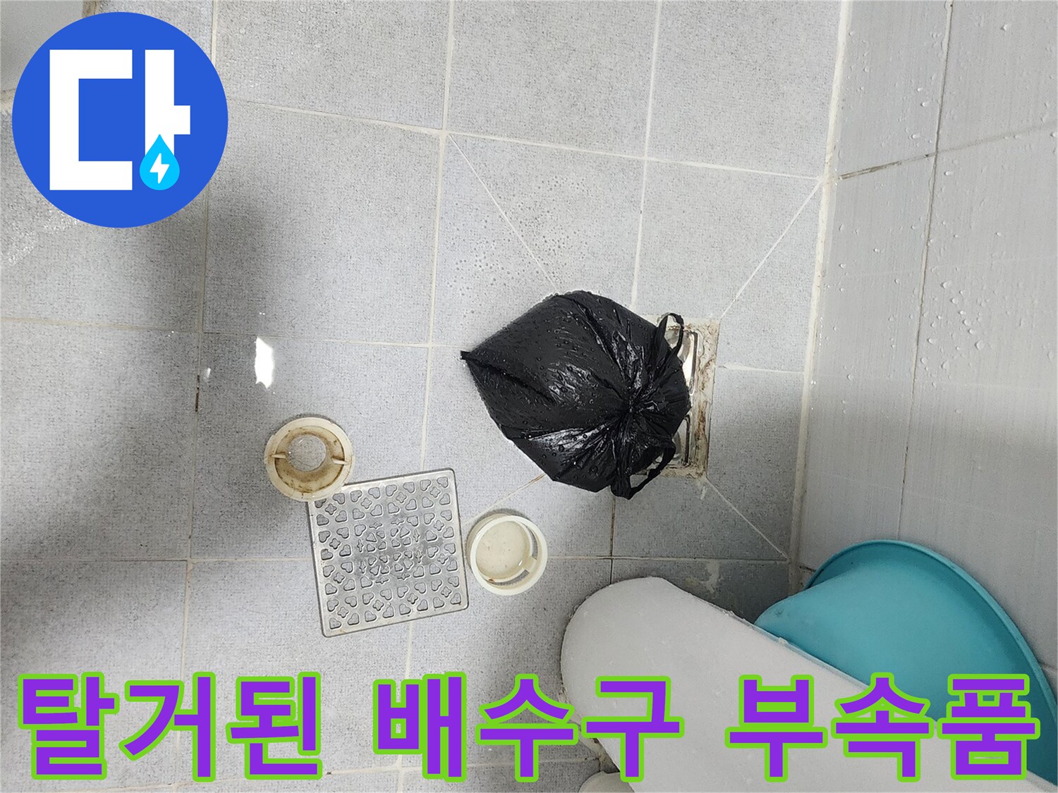 욕실 바닥 타일 위에 놓여있는 하수구 덮개와 내부 트랩 장치