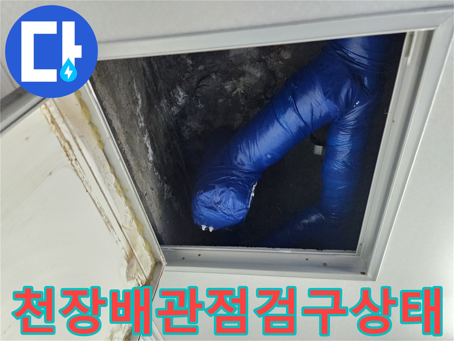천장 점검구 내부의 파란색 보온재로 감싸진 배관 모습