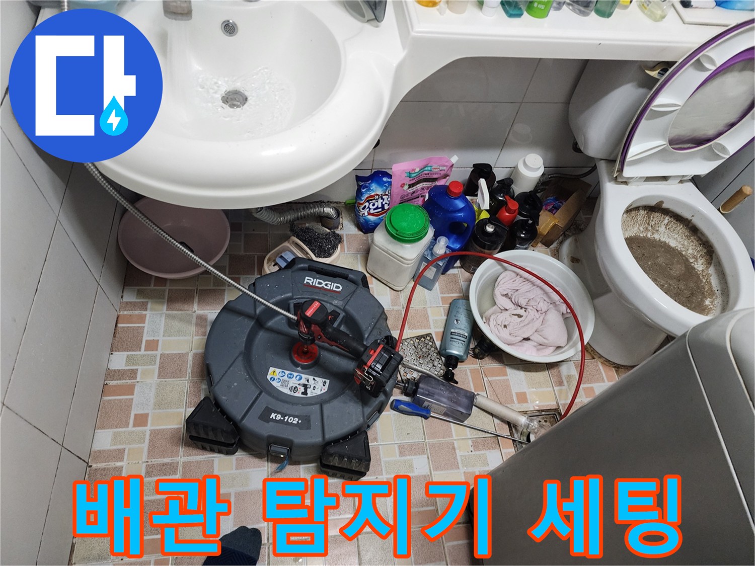 세면대 아래 바닥에 배치된 배관 청소용 전문 장비