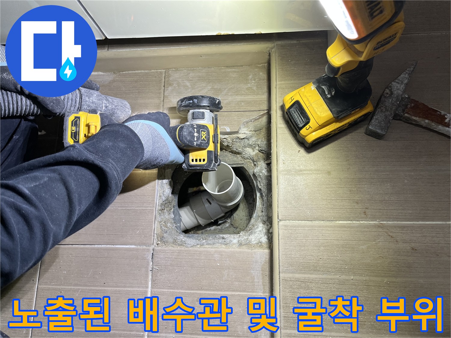 타일 아래 노출된 배수 파이프와 주변 작업 환경