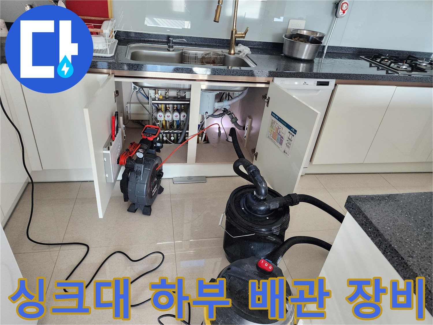 주방 싱크대 아래 배관 상태를 확인하기 위해 배치된 전문 탐지 장비와 석션기