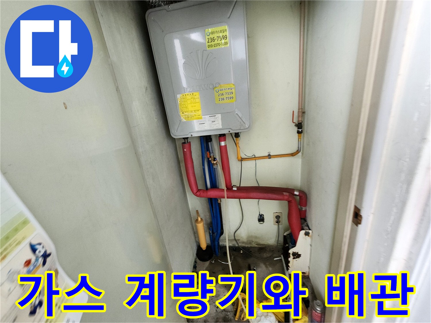 주방 하부장 내부의 가스 계량기와 붉은색 및 파란색 배관 구조