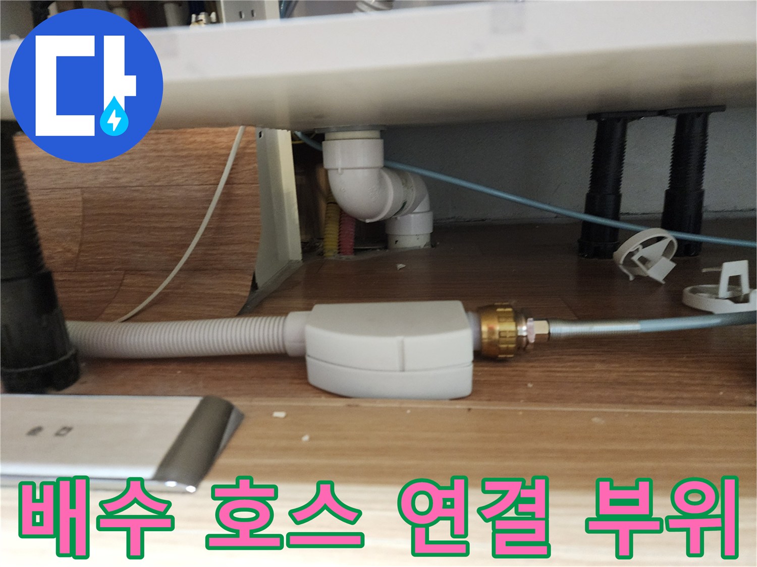 싱크대 아래쪽 하얀색 플라스틱 배관과 회색 주름관의 접합부