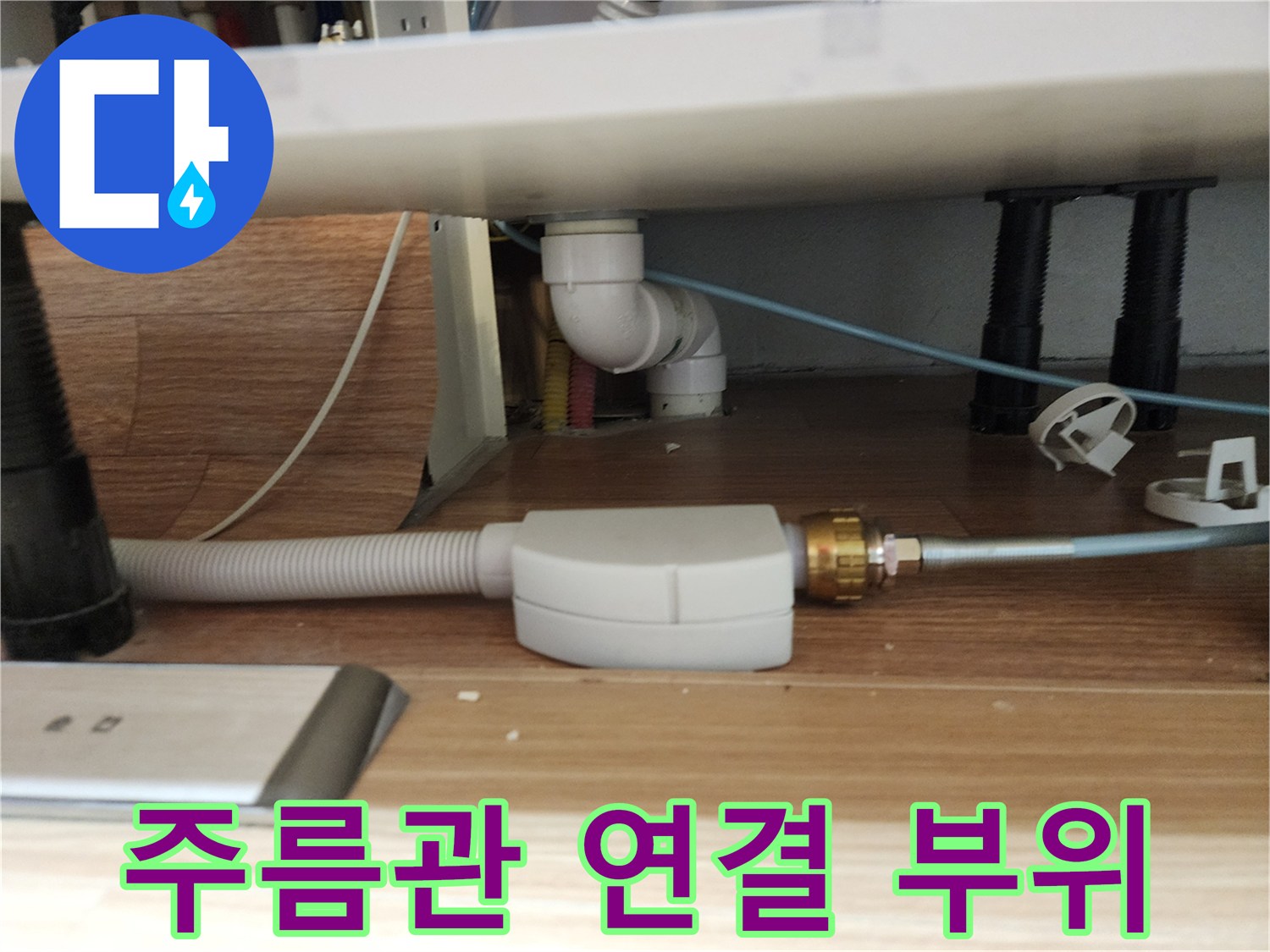 싱크대 아래쪽 흰색 주름 호스와 금속 연결 소켓 구조