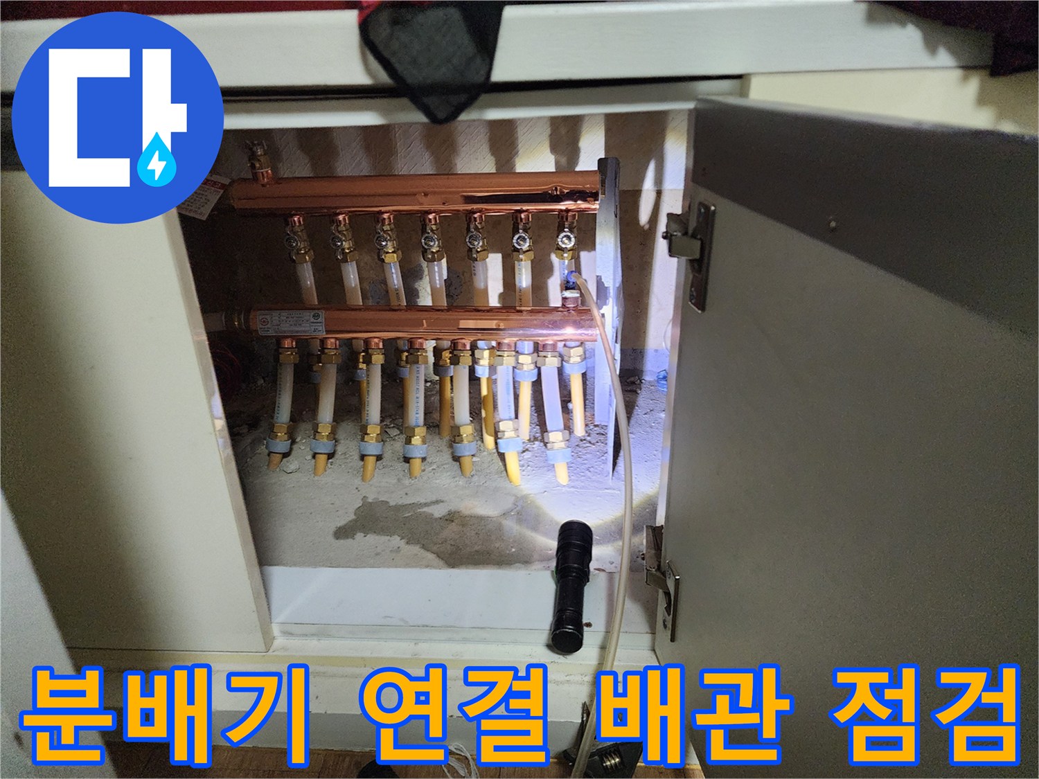 싱크대 하부장에 설치된 난방 분배기 및 배관들