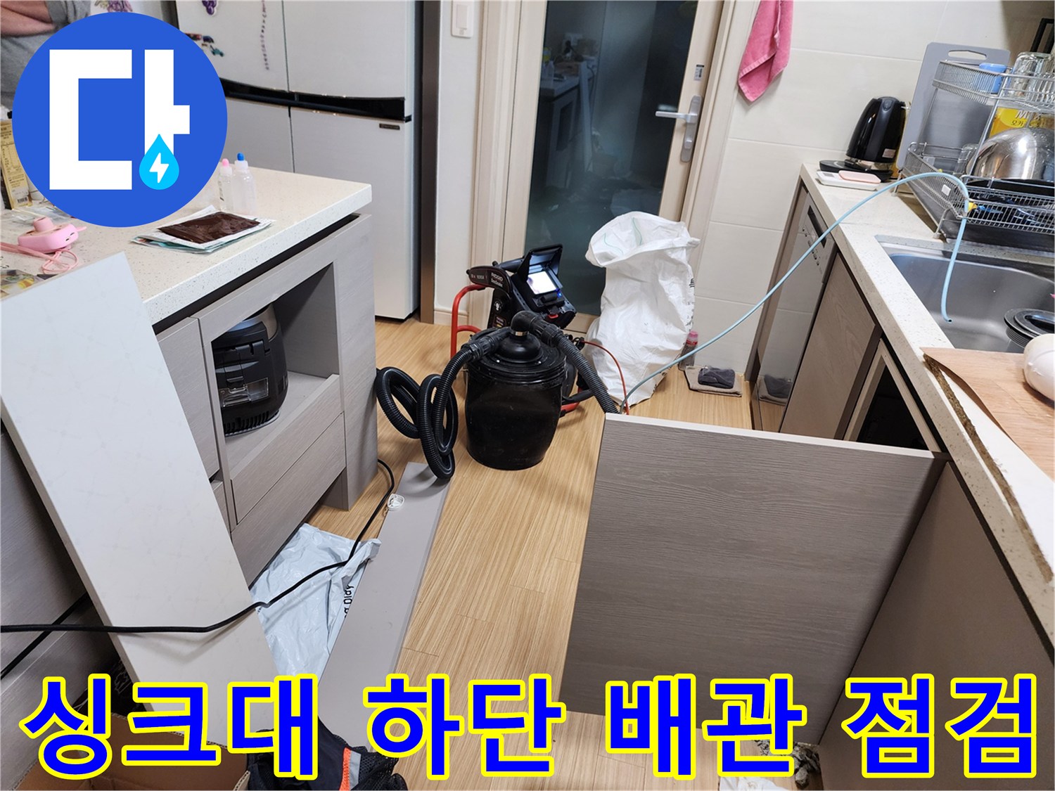 주방 싱크대 하부장 내부-배관 상태 확인 중